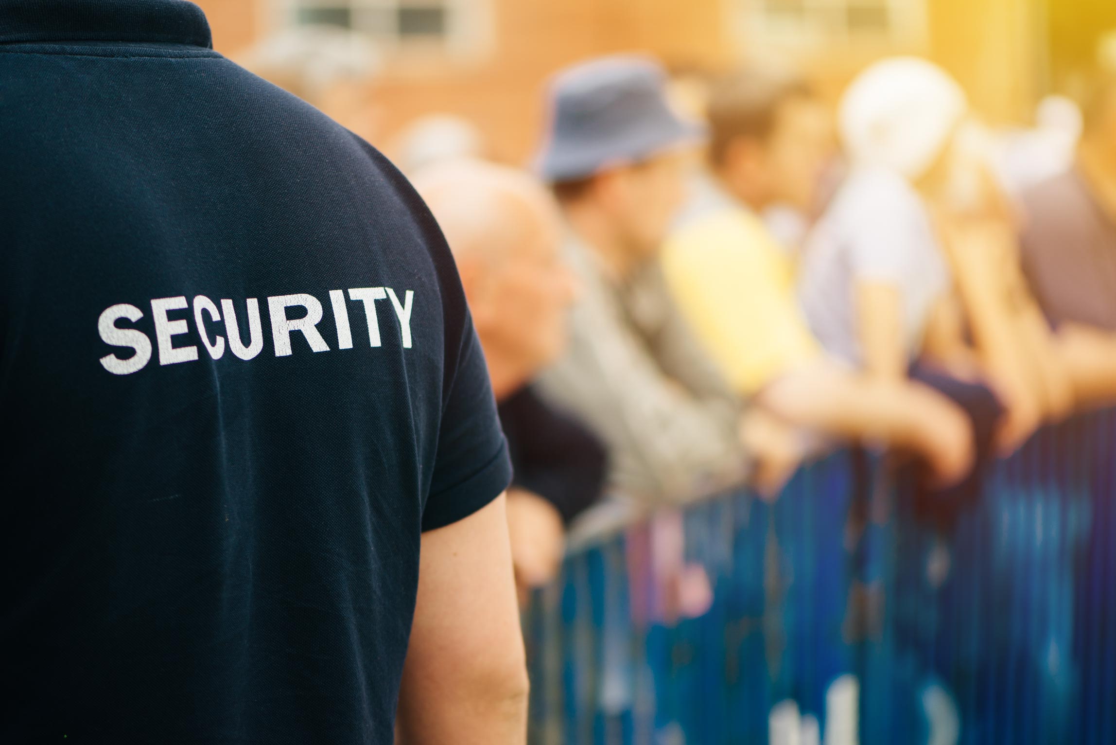 security officer and people behind a gated section