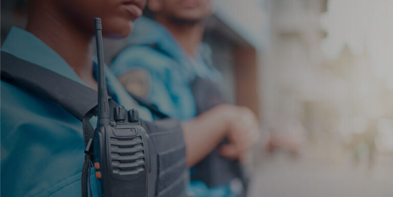 two security guards in blue uniforms with walk talkies