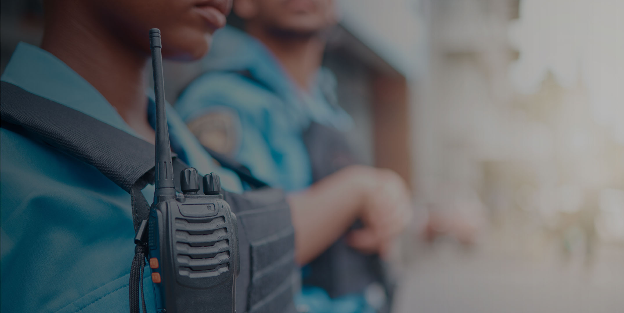 two security guards in blue uniforms with walk talkies