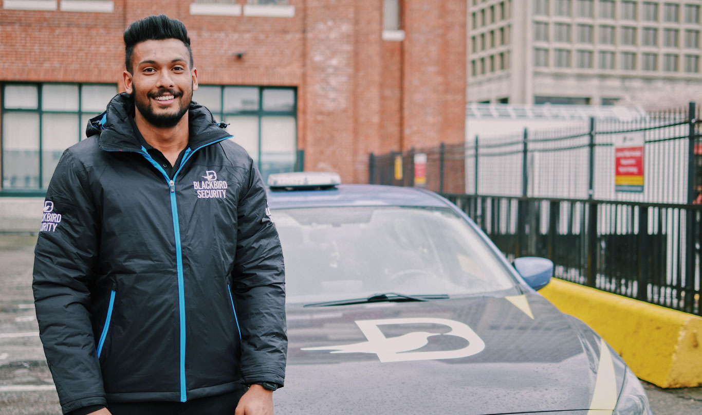 Blackbird Security guard next to a branded vehicle