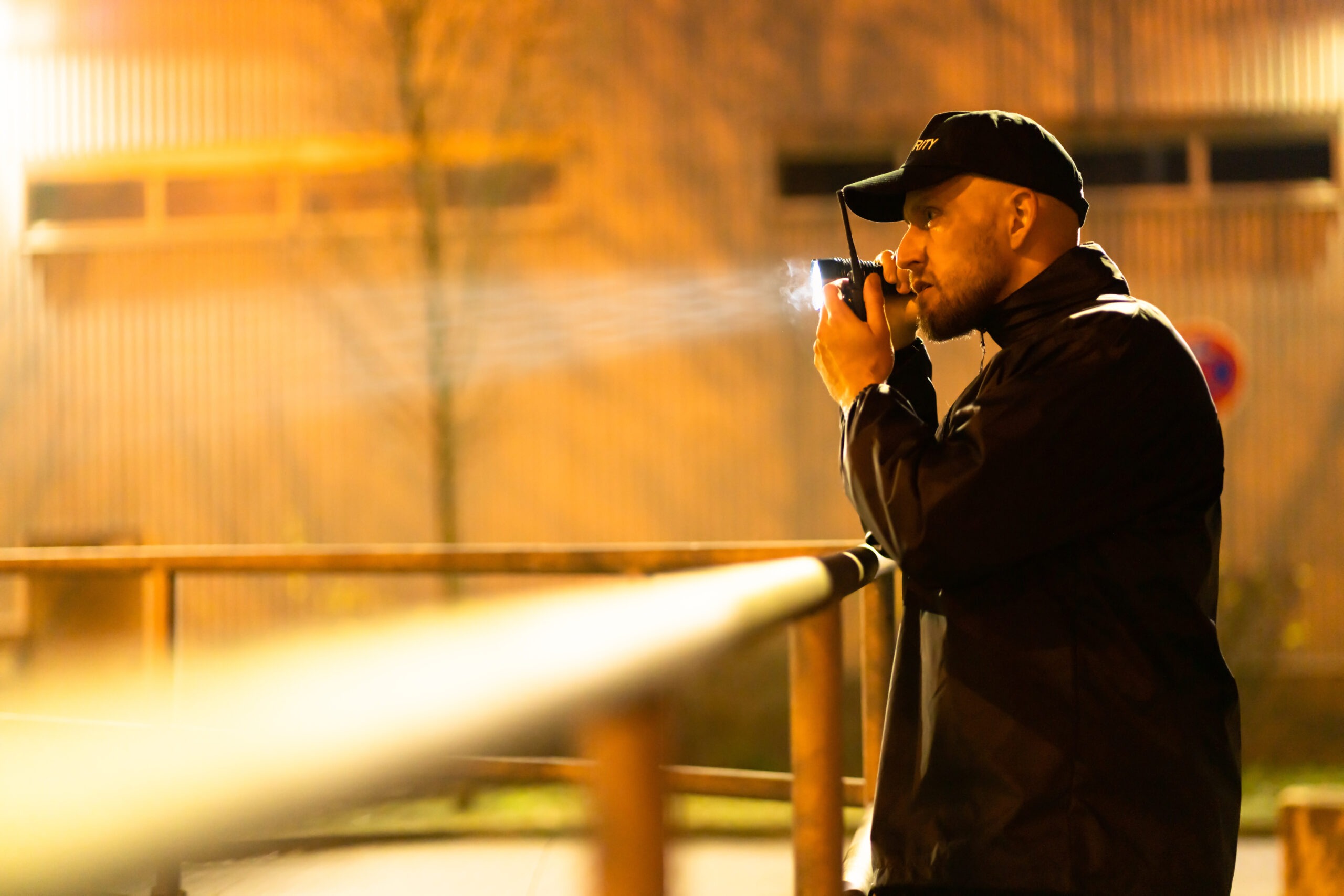 Security Guard Walking Outdoors With Flashlight At Night